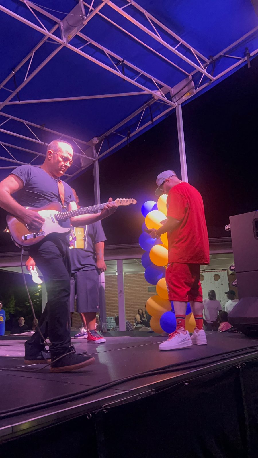 Q Bosilini on stage with a guitarist