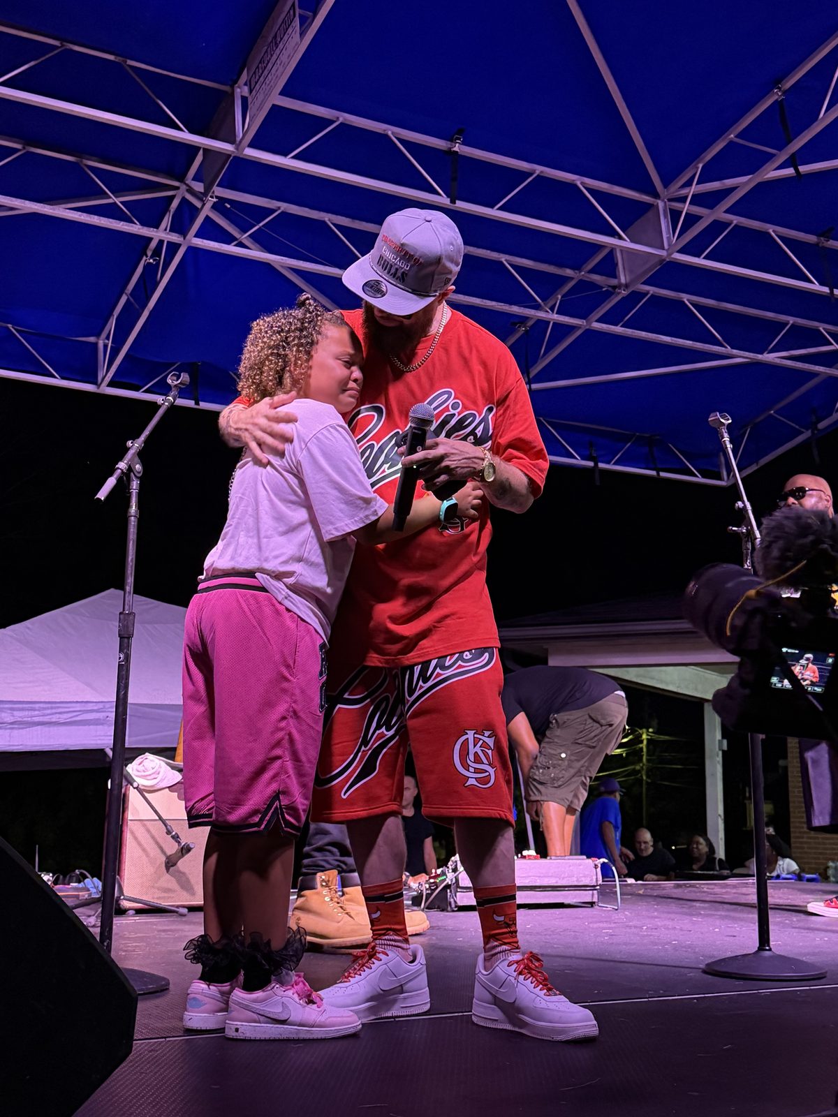 Q Bosilini embracing his daughter on stage after she performed with him